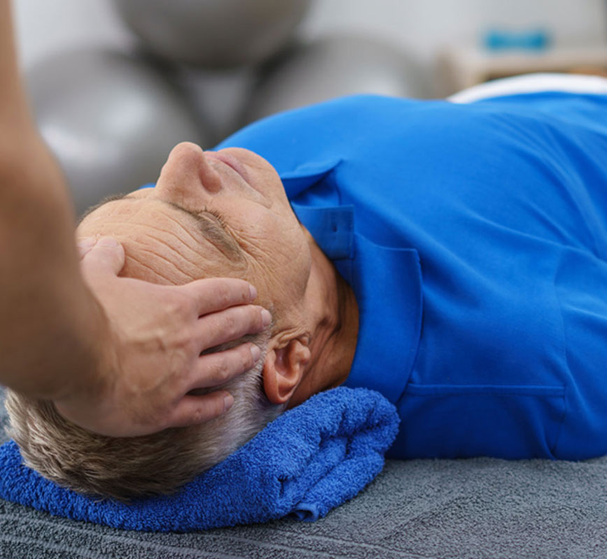 a man lying on a towel with his head in the air