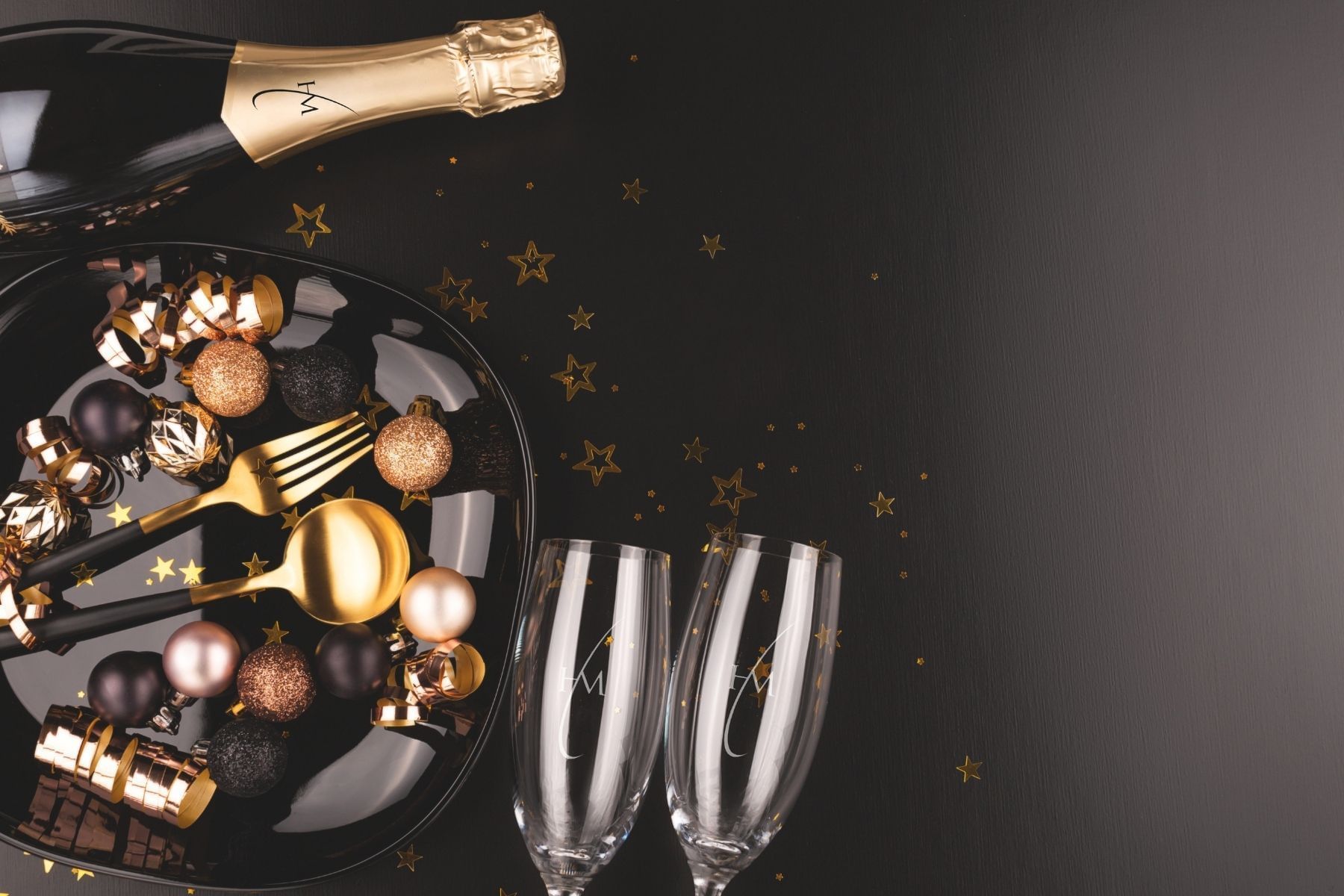 a plate with gold and black ornaments and champagne glasses