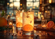 a couple of glasses with oranges and a candle