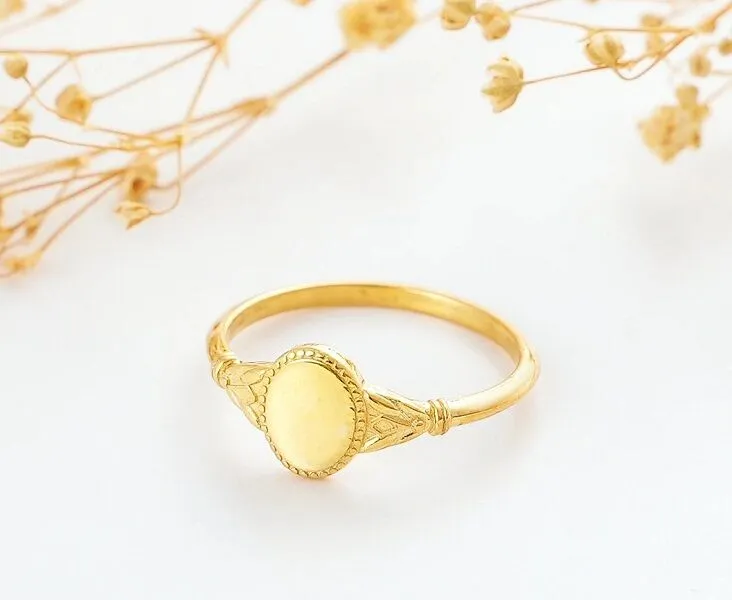 a gold ring with a round design on it