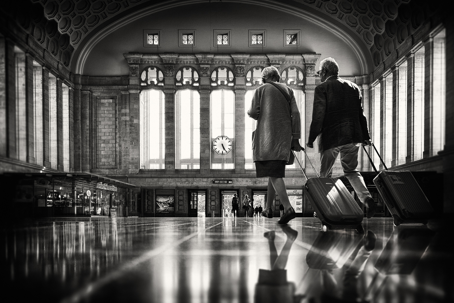 a couple of people with luggage in a train station
