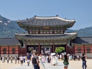 a group of people walking in front of Gyeongbokgung