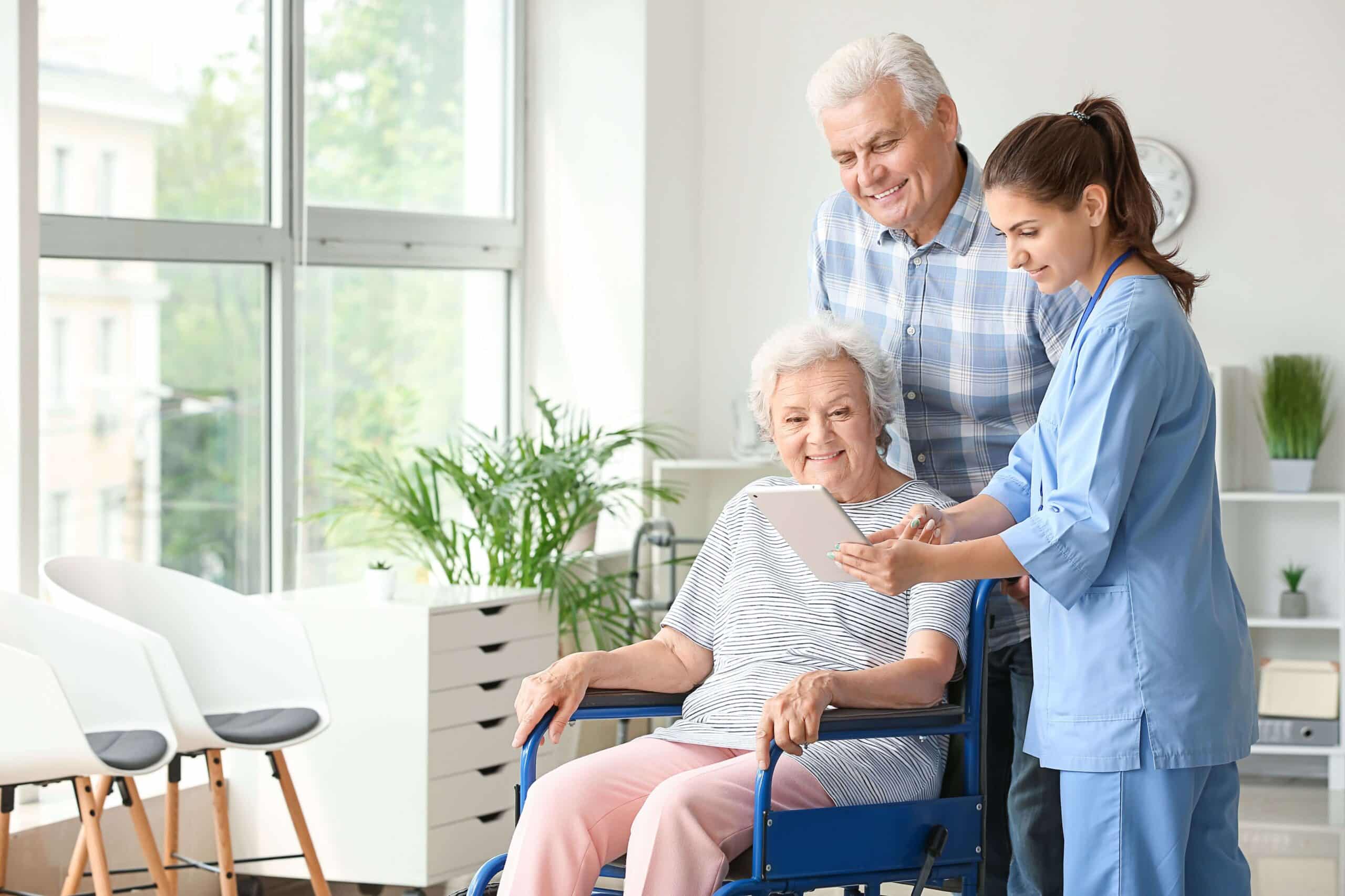 a woman in a wheelchair with a nurse and a man in a wheelchair