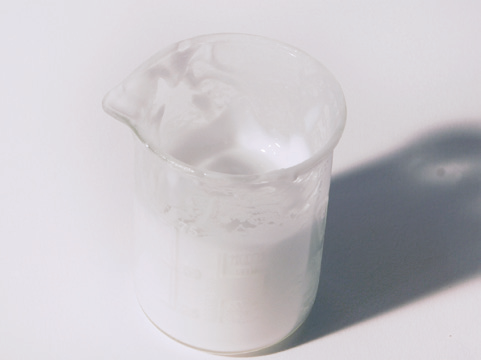 a glass beaker of white liquid