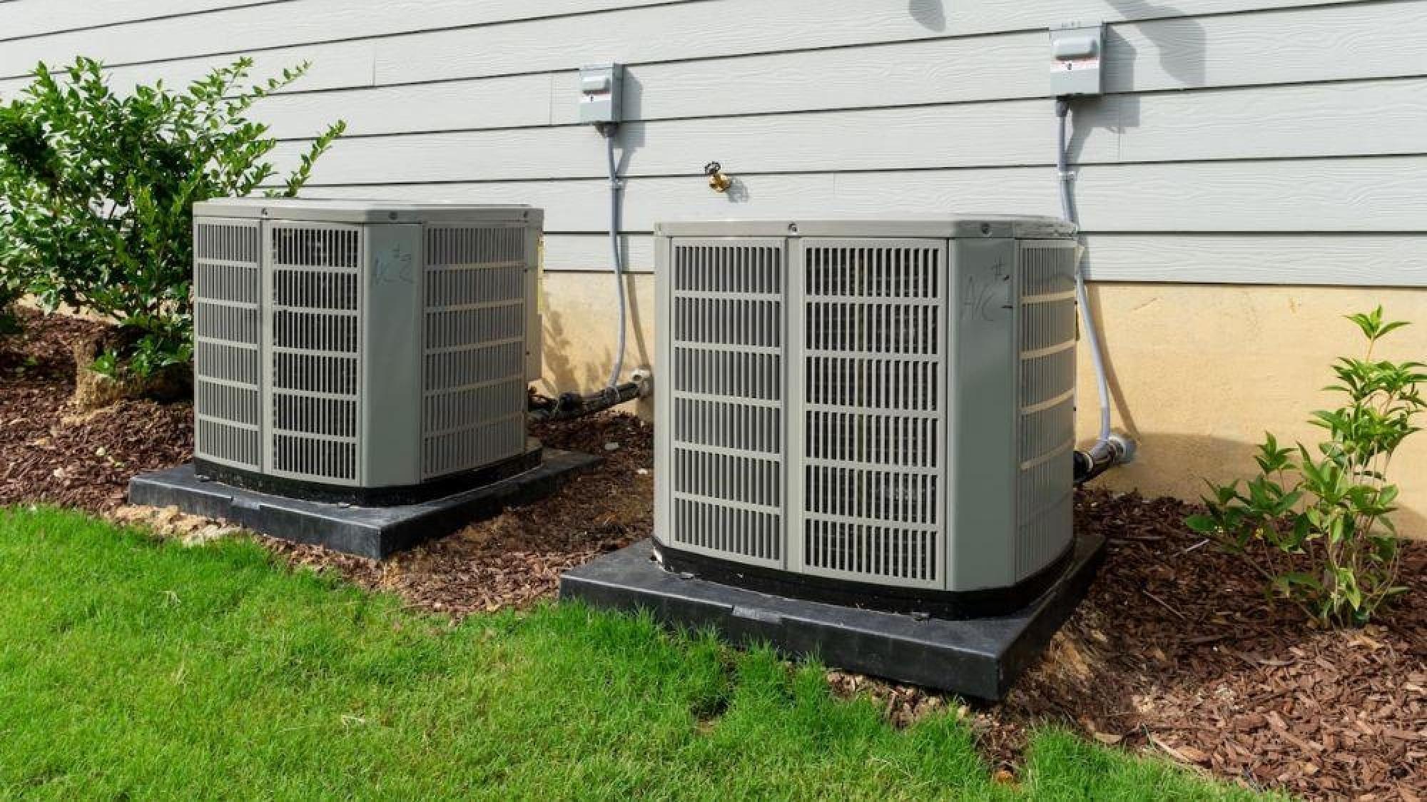 a couple of air conditioning units outside of a house