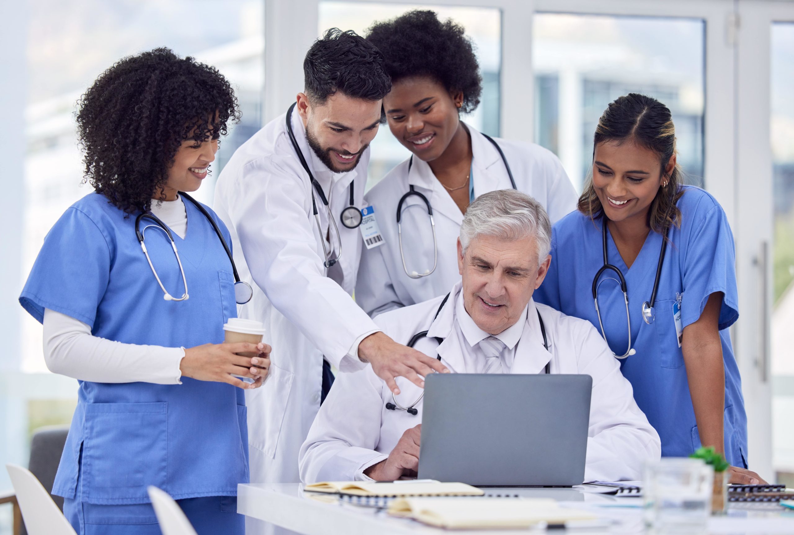 a group of medical professionals looking at a laptop