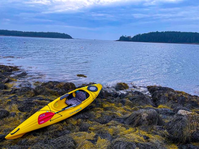 a yellow kayak on a rocky shore