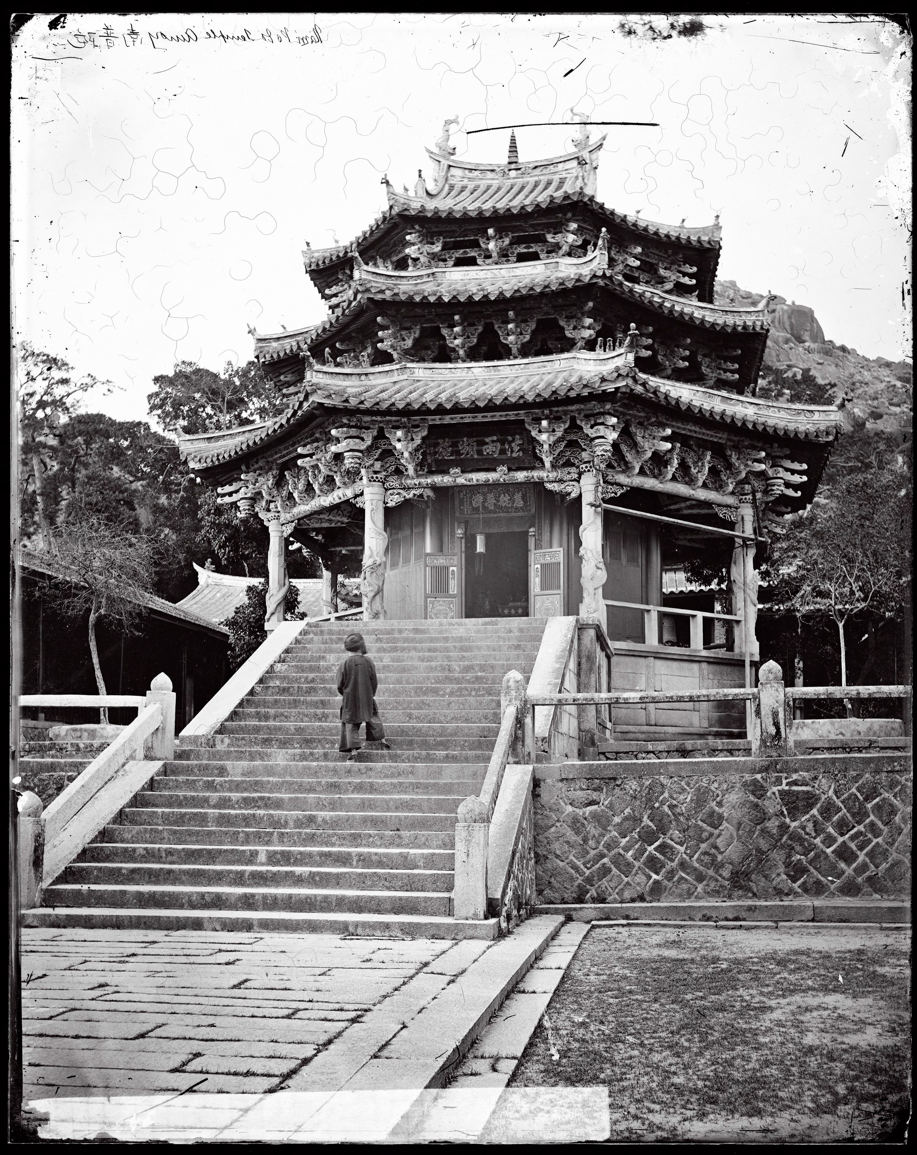 a person walking up stairs to a pagoda building