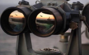 a binoculars with a view of a ship and a sunset