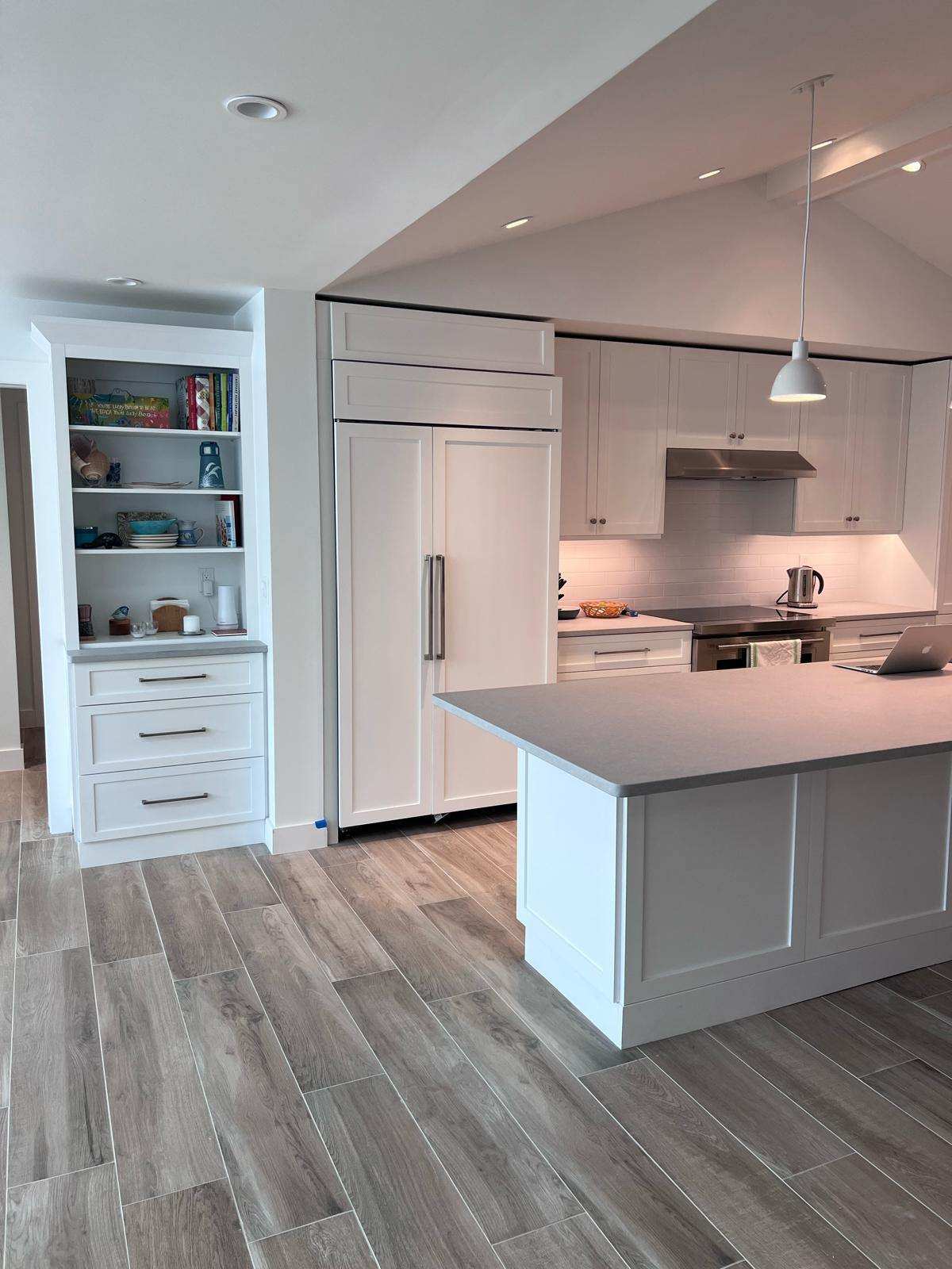 a kitchen with a wood floor and white cabinets