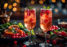 two glasses of wine with fruit on a table