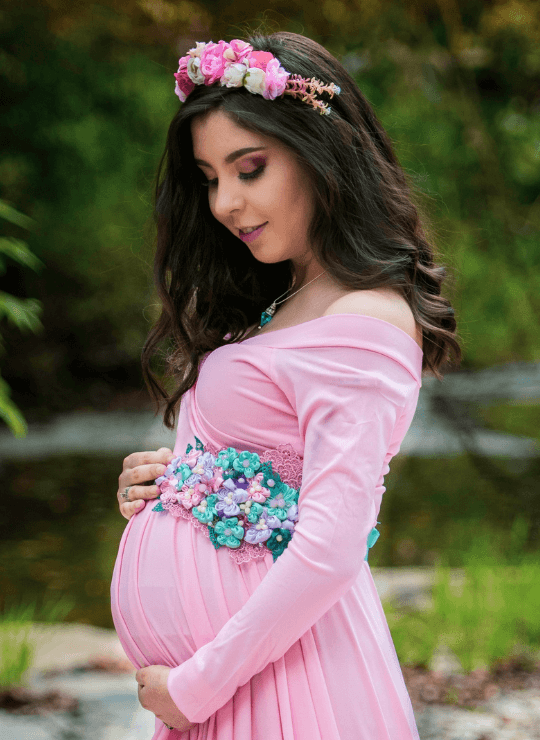a pregnant woman wearing a pink dress
