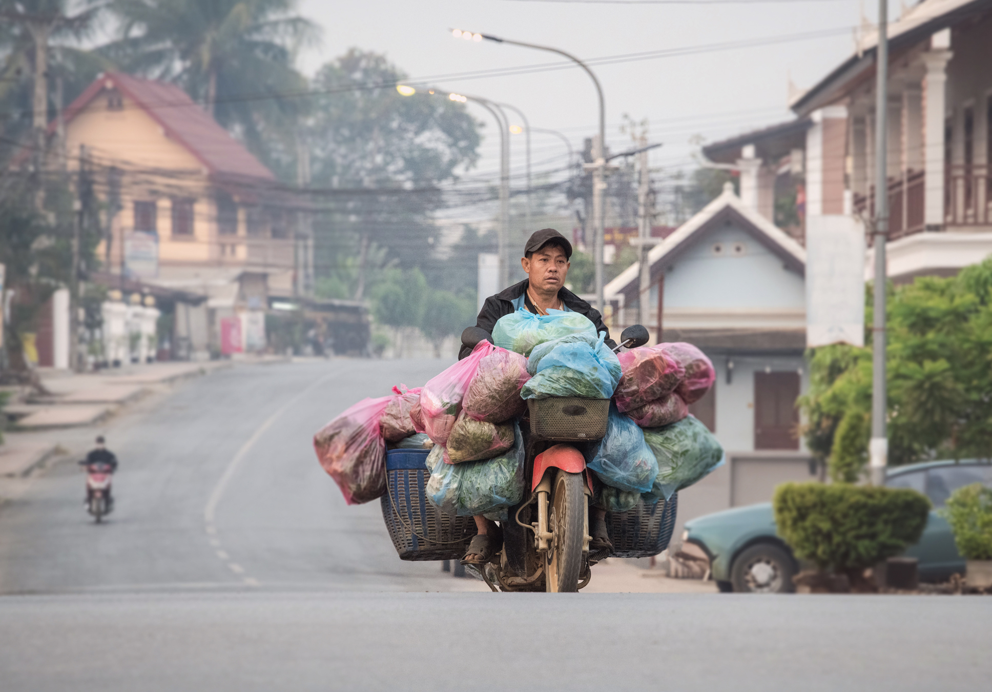 a man riding a motorcycle with many bags on it