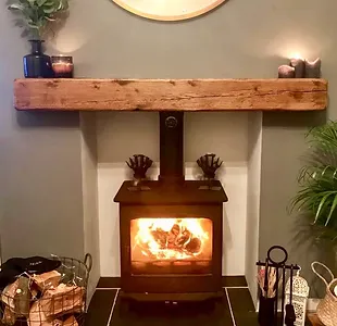 a fireplace with a wood shelf and plants