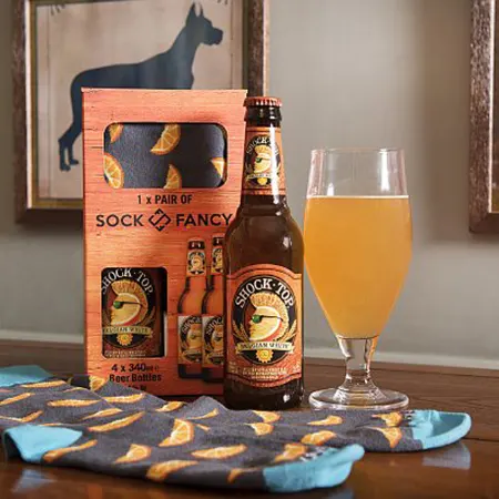 a glass of beer next to a box of socks