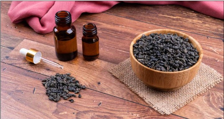 a bowl of black beans next to a bottle of essential oil