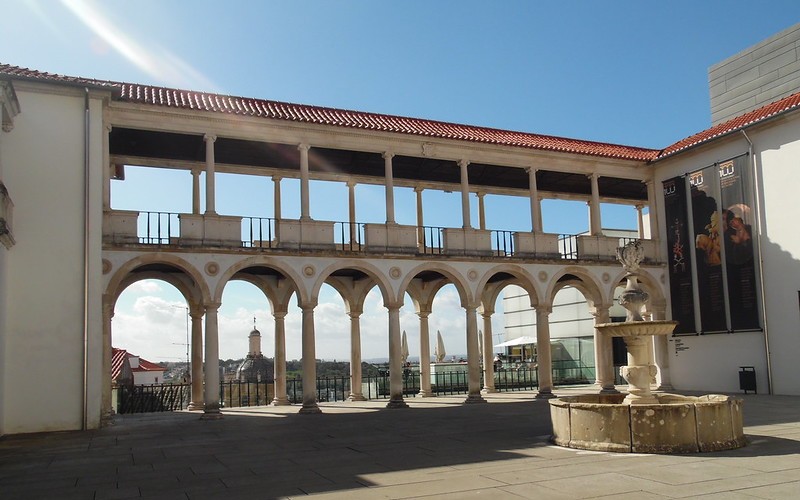 a building with a fountain and a building with columns