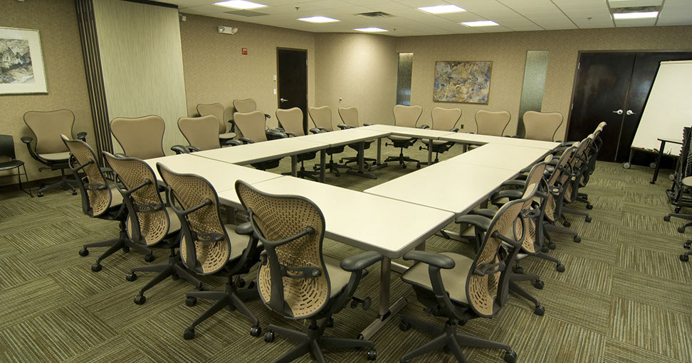 a conference room with a square table and chairs