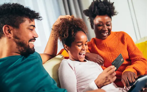 a group of people sitting on a couch looking at a cellphone