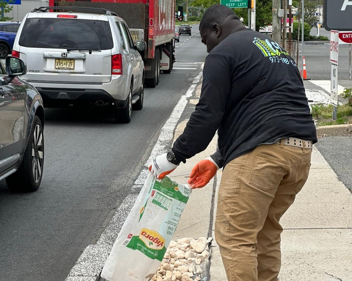 a man putting a bag of rocks on a curb