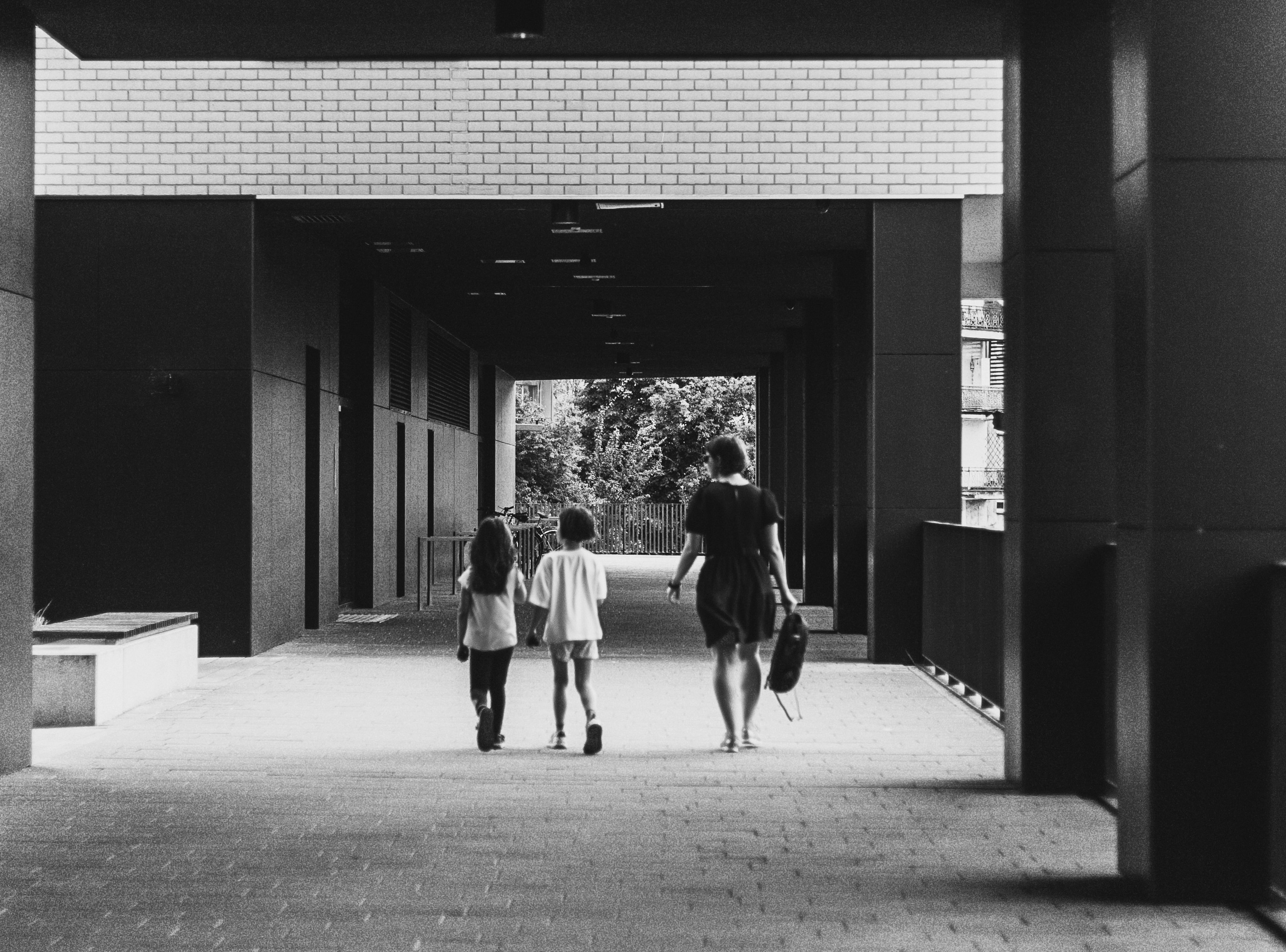 a woman and two girls walking down a walkway