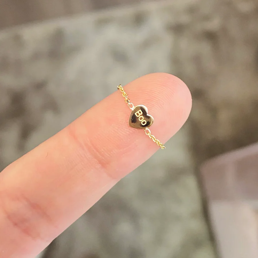 a finger with a gold heart on it