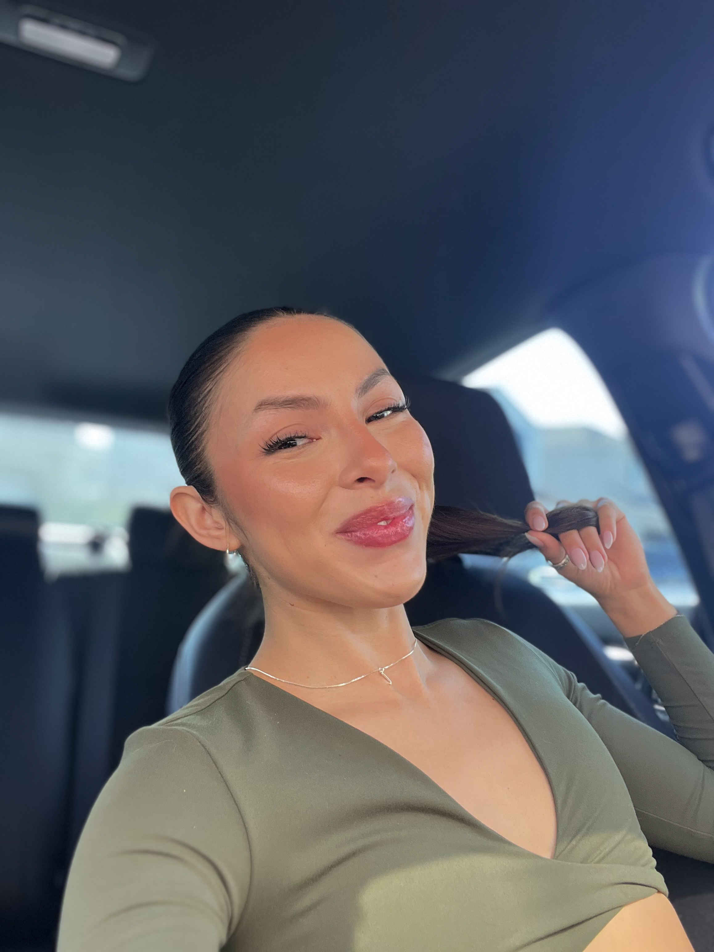 a woman holding her hair in a car