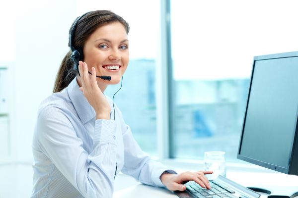 a woman wearing a headset and using a computer