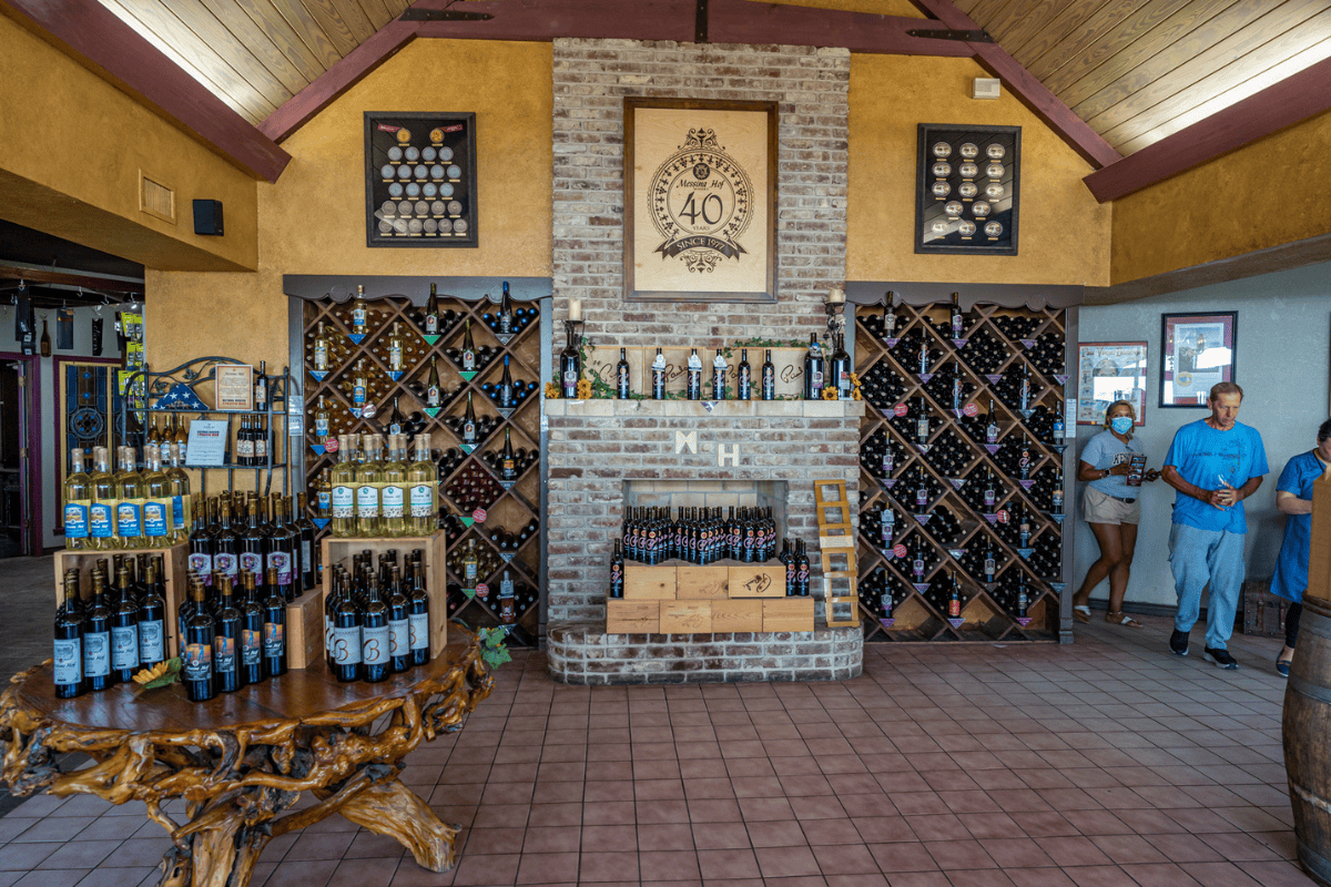 a room with a brick wall and shelves of wine bottles