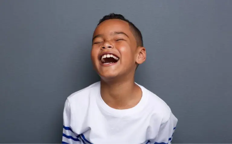 a boy laughing with his eyes closed