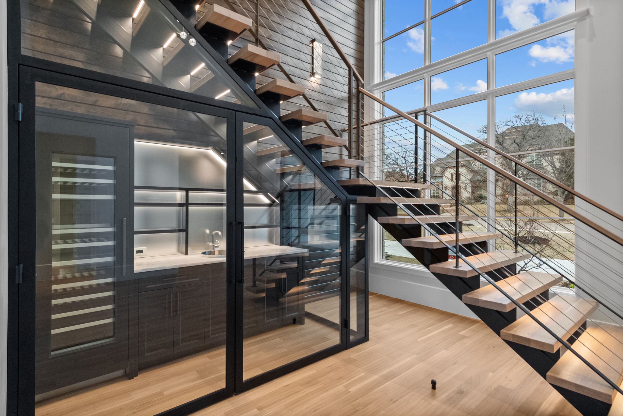 a staircase in a room with glass walls and a window