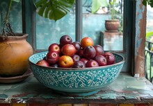 a bowl of fruit on a window sill