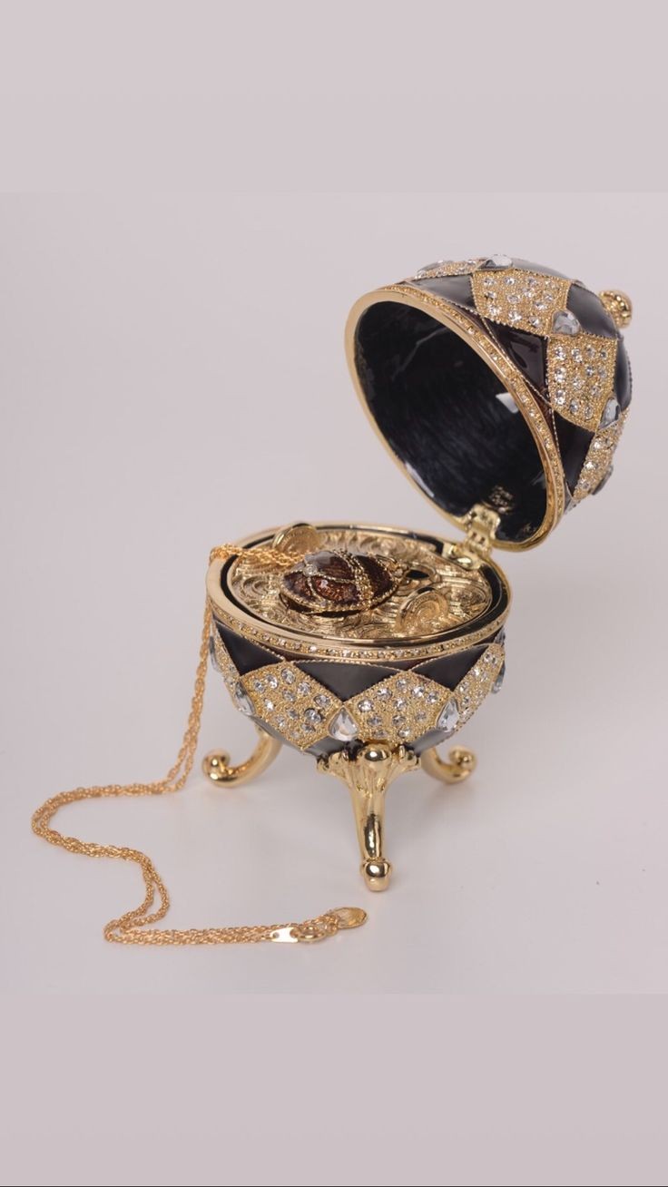 a jeweled egg shaped box with a gold chain