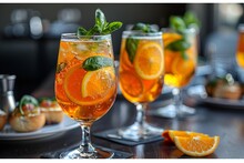 a group of glasses with oranges and mint in them