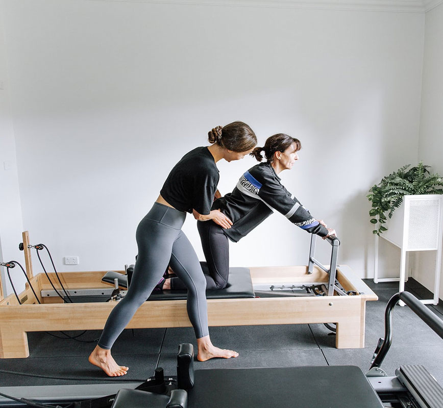 a woman on a reformer