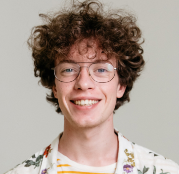 a man with curly hair wearing glasses