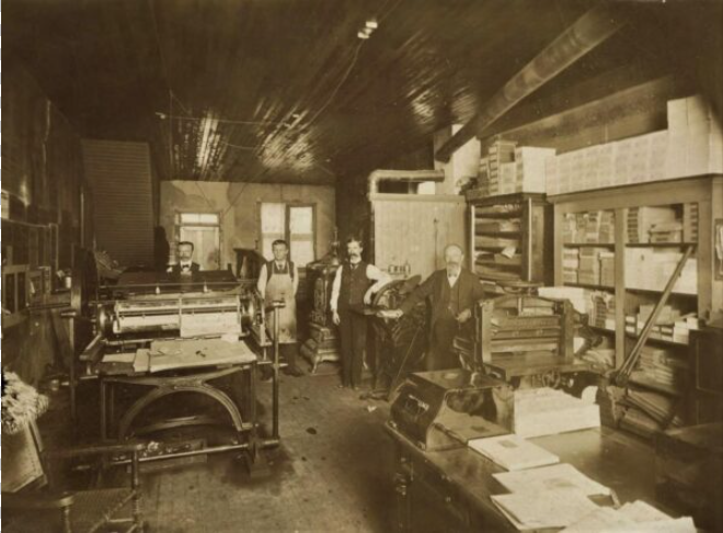 a group of men in a printing room