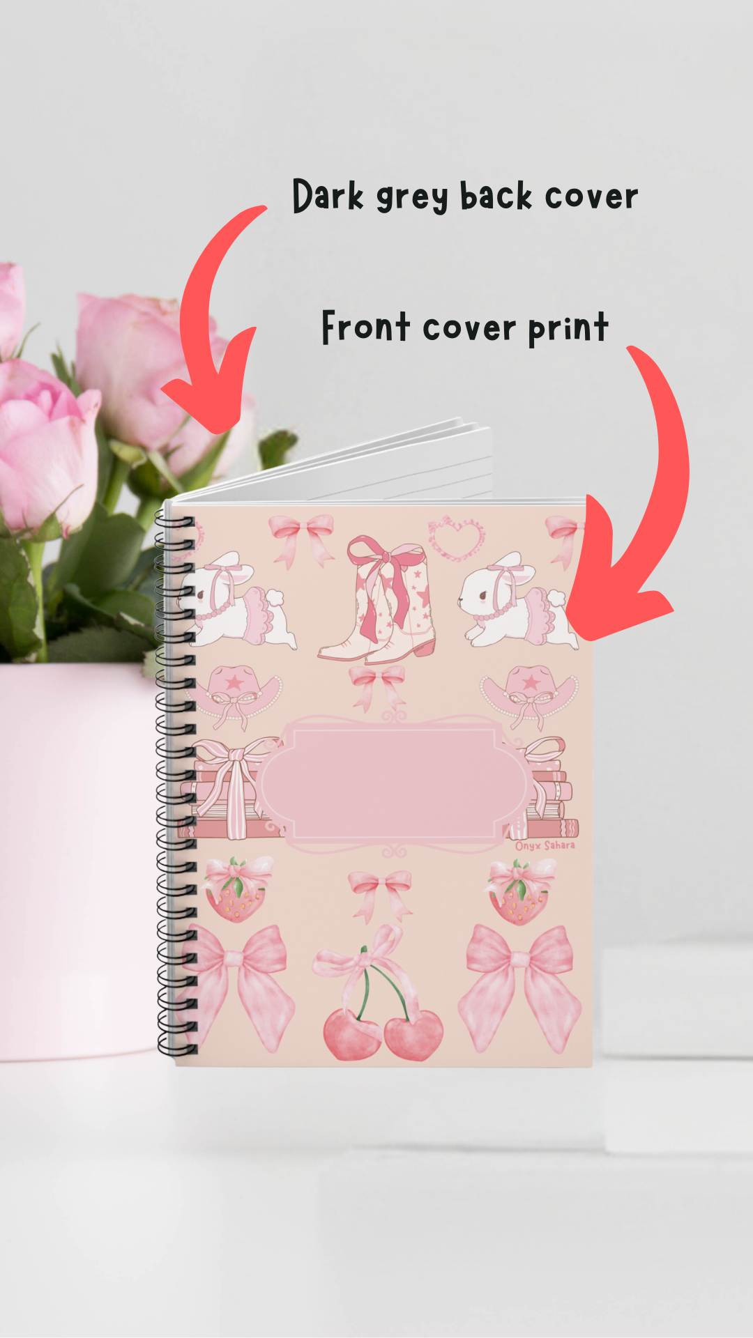 a notebook with a pink cover and a pink vase of flowers