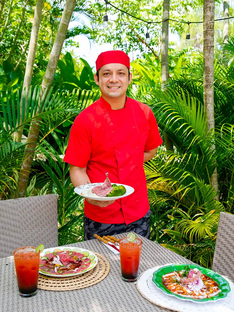 a man in a red uniform holding a plate of food