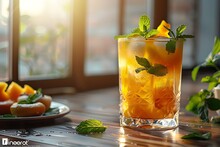 a glass of orange drink with mint leaves