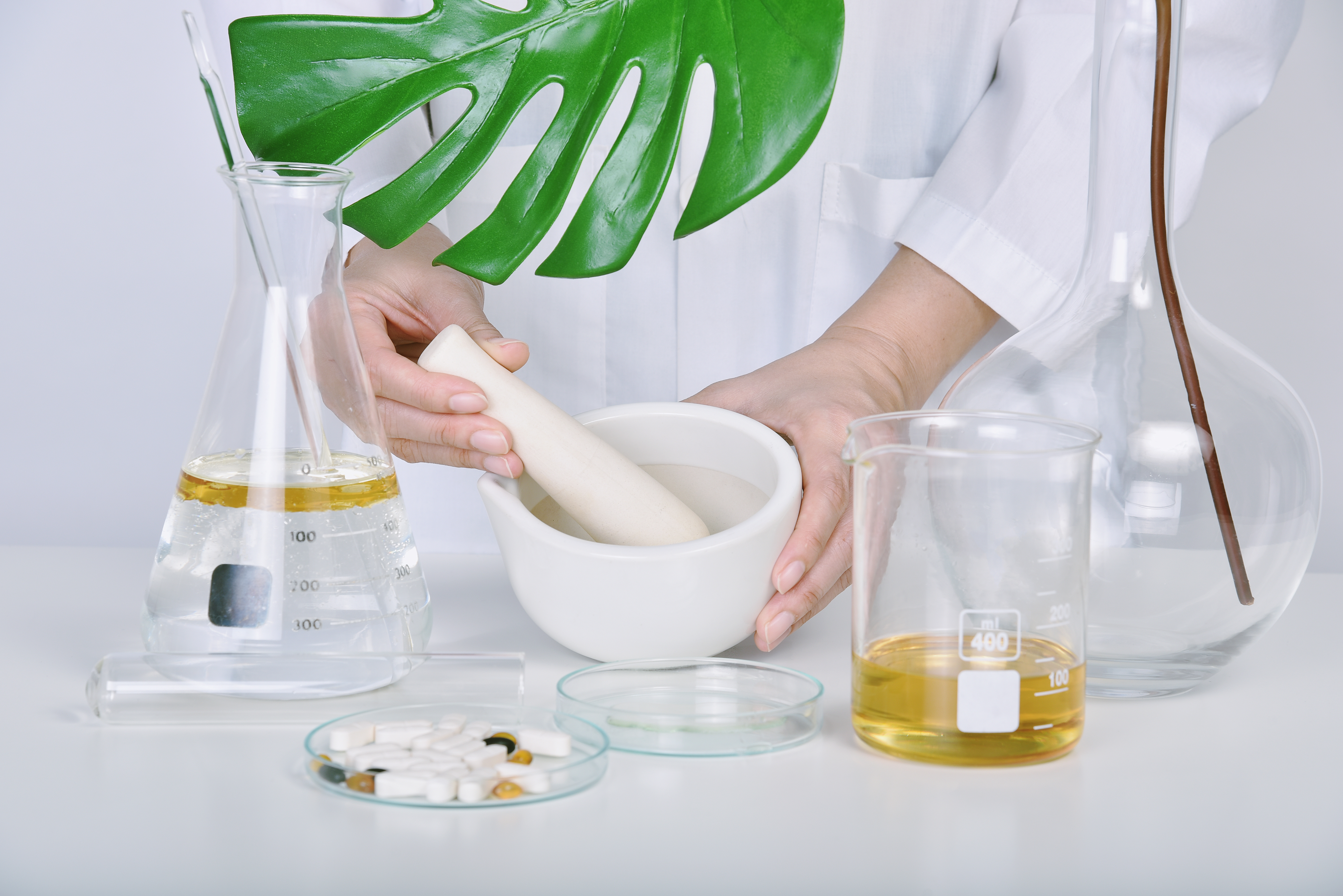 a person in a lab coat holding a mortar and pestle