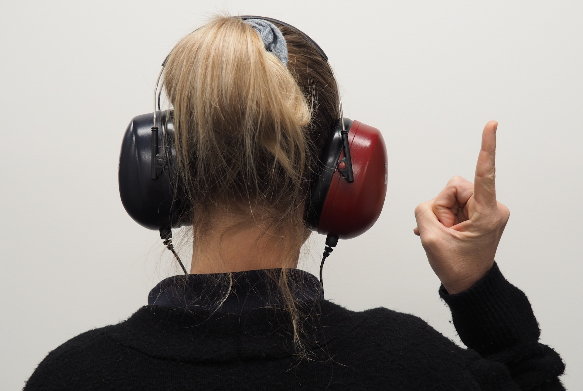 a woman wearing headphones and pointing up