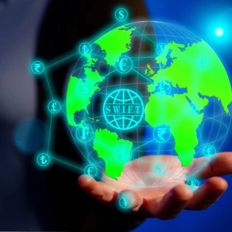a hand holding a globe with currency symbols