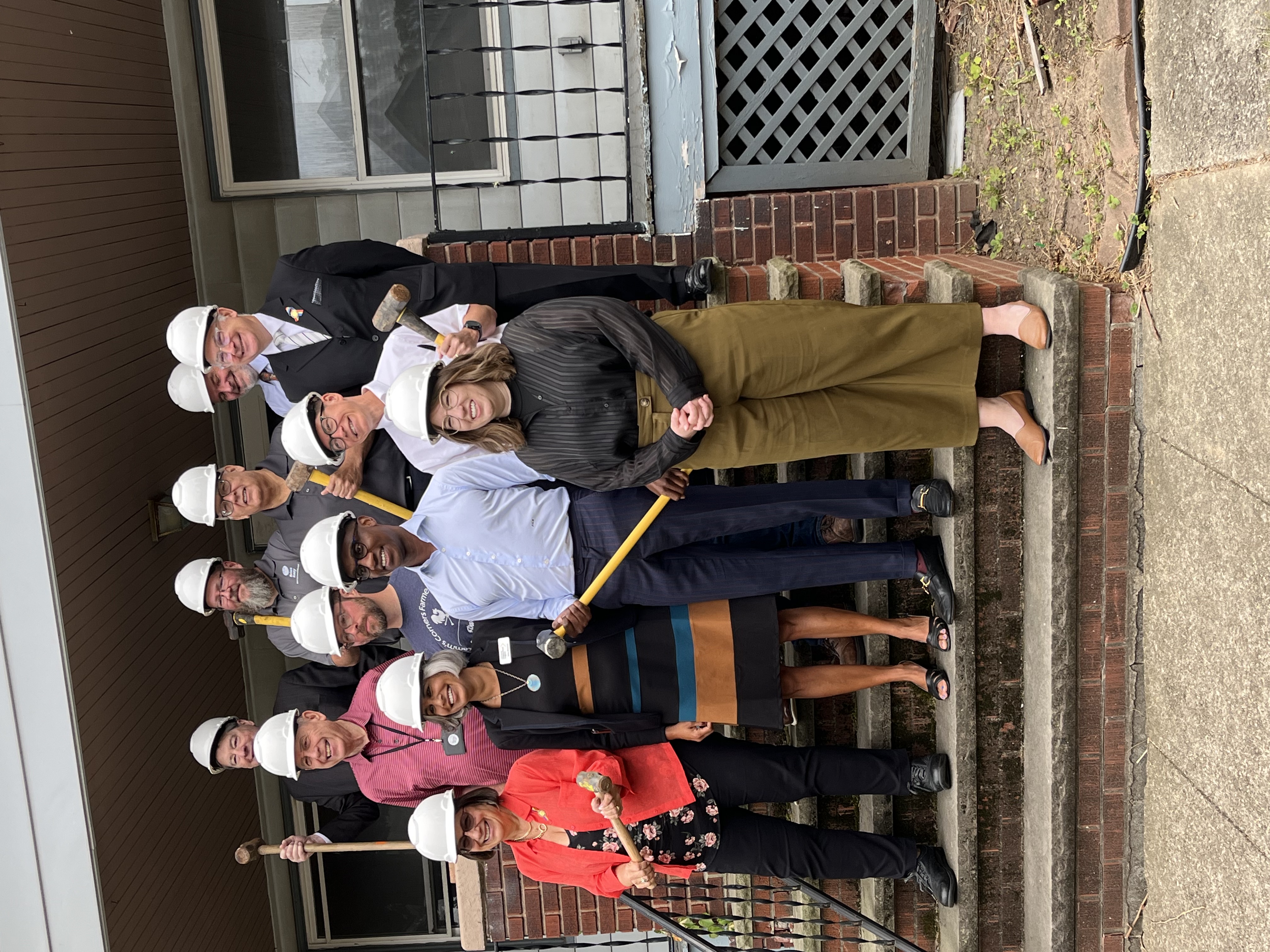 a group of people wearing hard hats and holding hammers