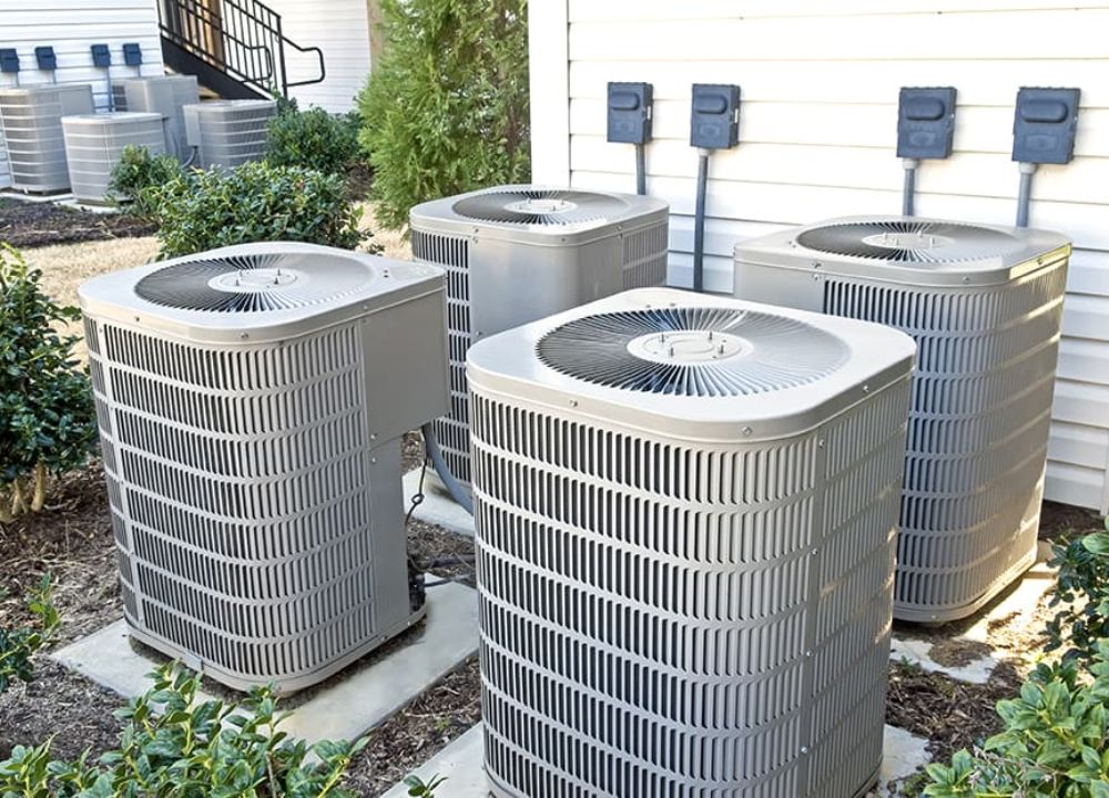 a group of air conditioning units outside a house