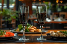 a couple of wine glasses on a table with food on it