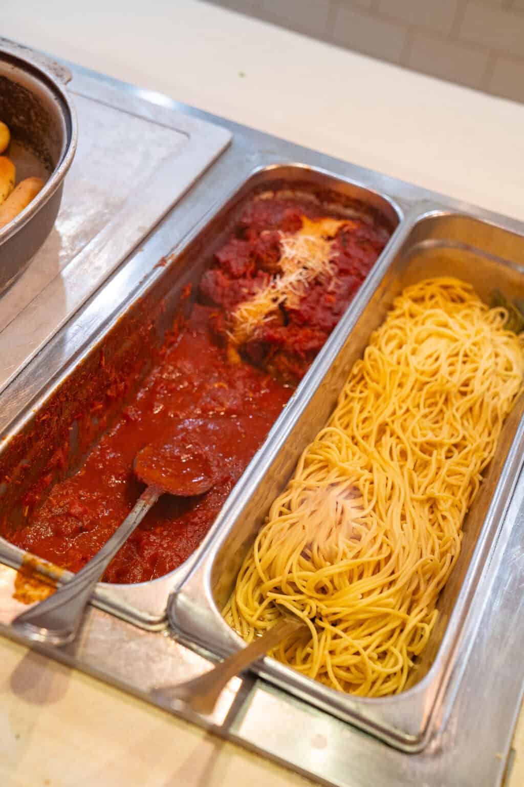 a tray of food with spaghetti and sauce
