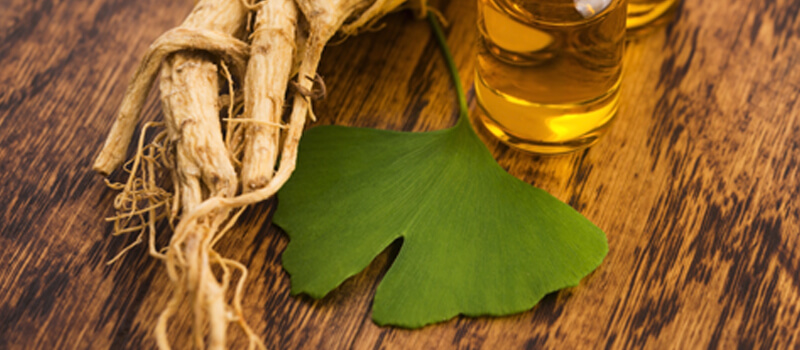 a ginkgo biloba root and a glass of oil