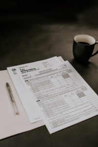 a cup of coffee and papers on a table