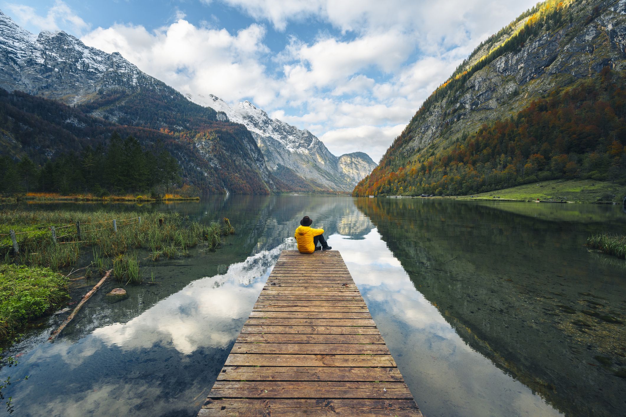 a person sitting on a dock overlooking a lake